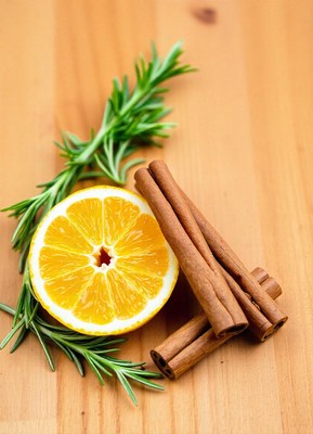 Lemon wedge, cinnamon, and rosemary on wood