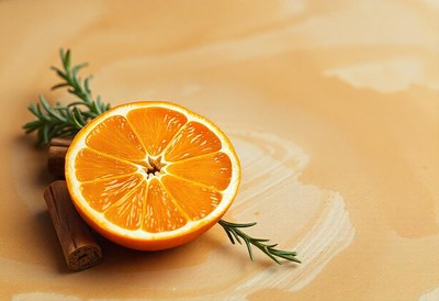 A single orange half rests on a beige background