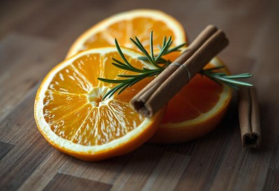 Orange slices, cinnamon, and rosemary on wood