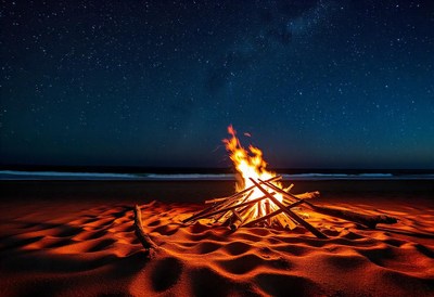 A bonfire on the beach under a starry night