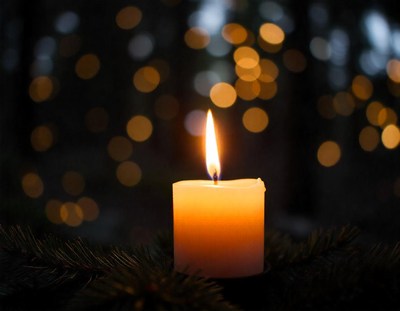 One candle shines amid twinkling lights
