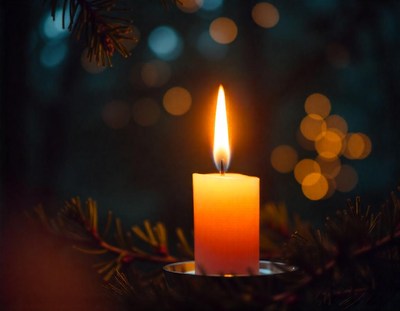 A single candle burns brightly against a dark background