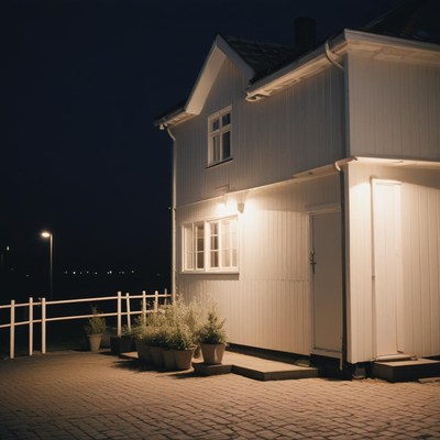 A white house with a lit doorway at night