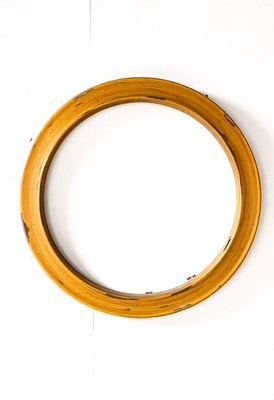 A golden wood frame hangs on a white wall