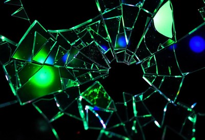 Shattered glass reflects green and blue light