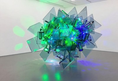 Glass sculpture with green and blue lights in gallery