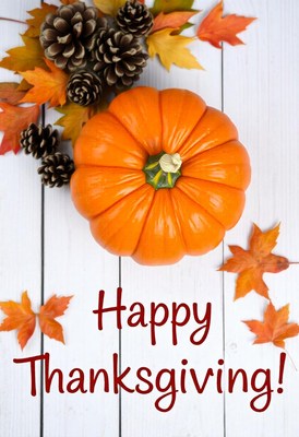 An orange pumpkin sits on a white wooden surface