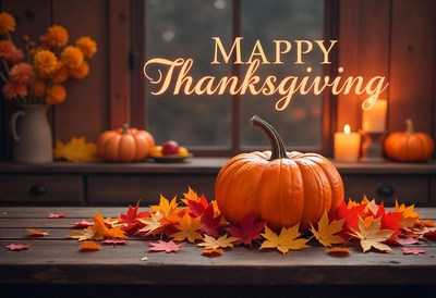 A pumpkin sits on a table with fall leaves