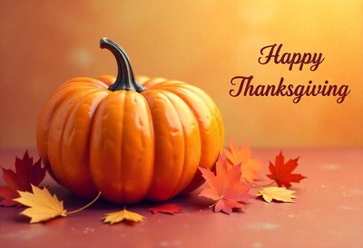 A pumpkin sits on a table with fall leaves