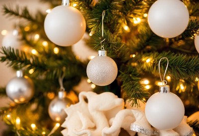 White and silver ornaments adorn a christmas tree