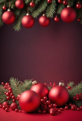 Red christmas ornaments hang from a pine branch