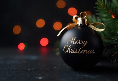 Black ornament with gold lettering on dark surface