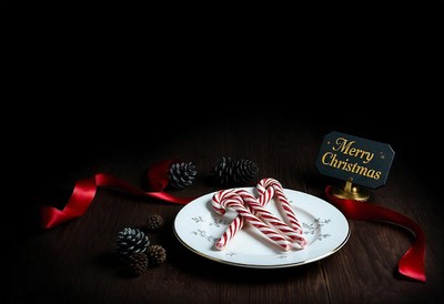 Candy canes on a plate with a festive sign