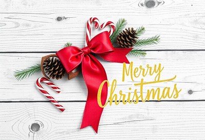 A red bow and candy canes on a white wooden background