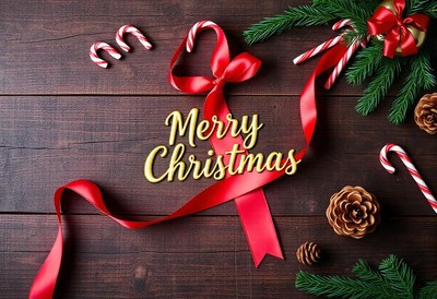 Red ribbon and candy canes on a wooden table for christmas