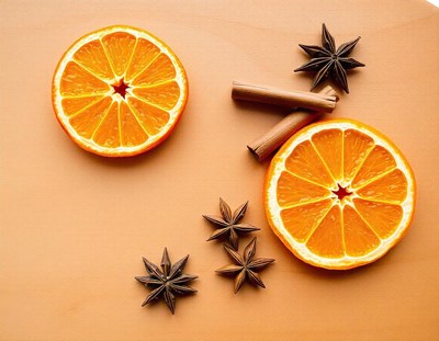 Two orange slices and star anise on a brown surface