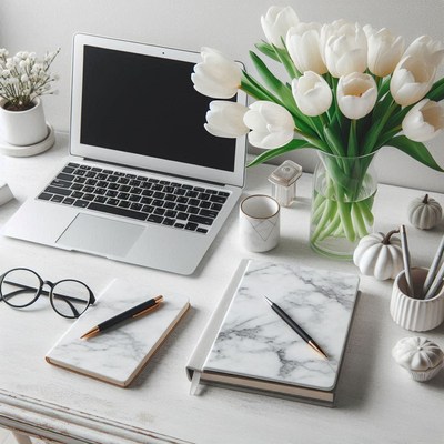 White desk with laptop, notebooks, and tulips
