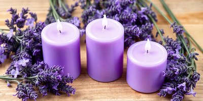 Three purple candles on wood with lavender