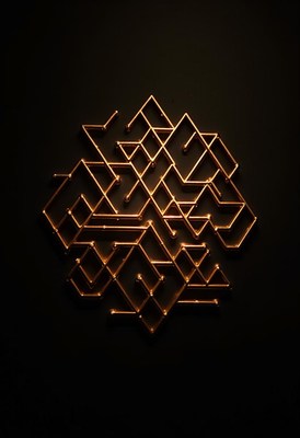 A gold geometric design on a dark wall