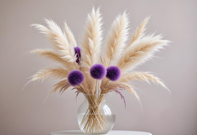 Vase of pampas grass and purple flowers on table