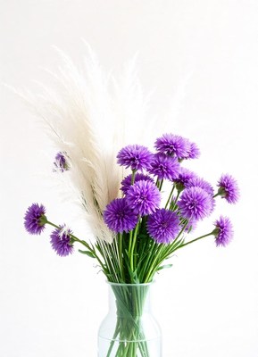 Purple flowers and white pampas grass in a vase