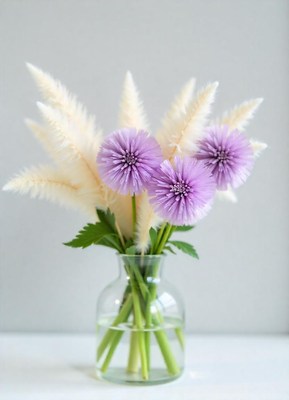Purple flowers and white pampas grass in a vase