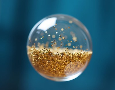 Gold glitter sphere on blue background