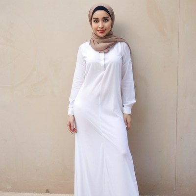 Woman in white dress and brown scarf by a wall