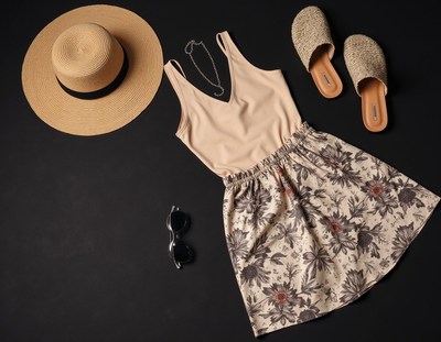 Skirt, tank top, and sandals on a black surface