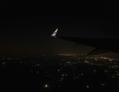 A plane wing and city lights at night