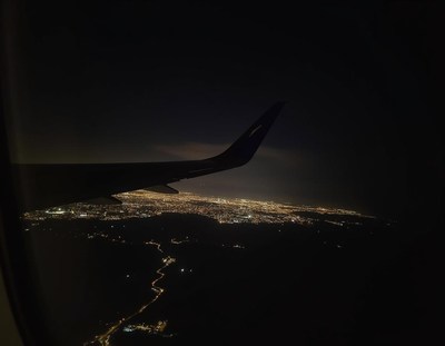 A view of city lights from an airplane window at night