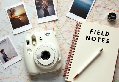 A white instant camera on a map awaits travel memories