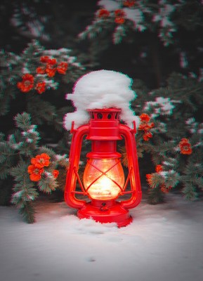 A red lantern sits in the snow, glowing brightly
