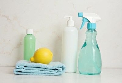 Cleaning supplies and lemon on a towel in bright kitchen