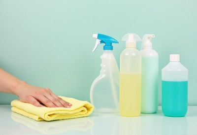 Cleaning supplies and a hand preparing to wipe