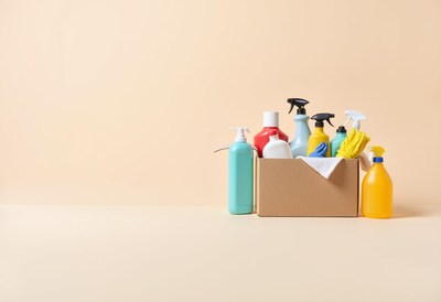 Cleaning supplies arranged in a box on a neutral background