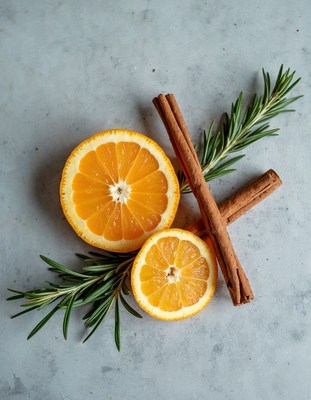 Orange slices with cinnamon and rosemary on gray