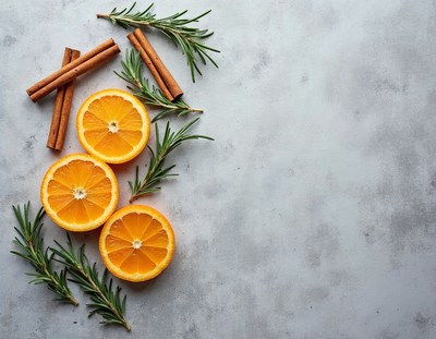 Fresh oranges and herbs on a gray surface