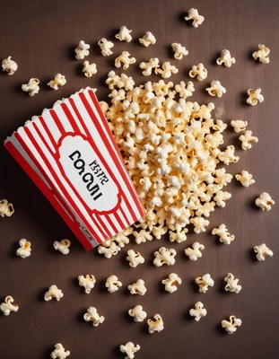 Popcorn scattered around a striped container on a table