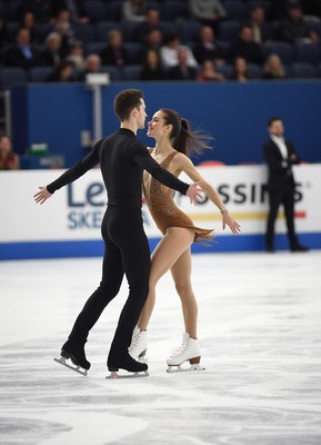 Ice dancers perform a captivating routine indoors
