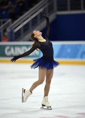 Skater performs elegant routine on ice during competition