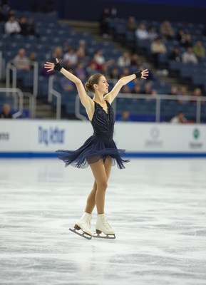 Skater performs graceful routine on ice rink in competition