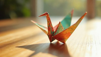 Colorful origami cranes on wooden surface in sunlight