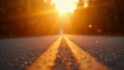 Sunlight illuminating a long road at sunset