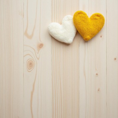 Two knitted hearts on a wooden surface