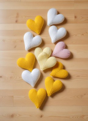 Knitted hearts arranged on a wooden floor