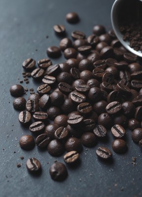 Rich coffee beans scattered on dark surface