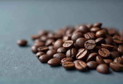 Roasted coffee beans scattered on a dark surface