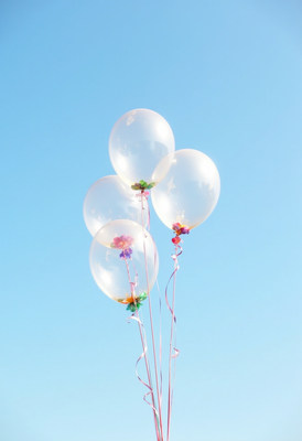 Colorful balloons floating against a clear blue sky