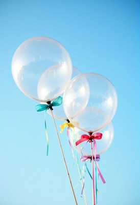 Colorful balloons floating against a clear blue sky